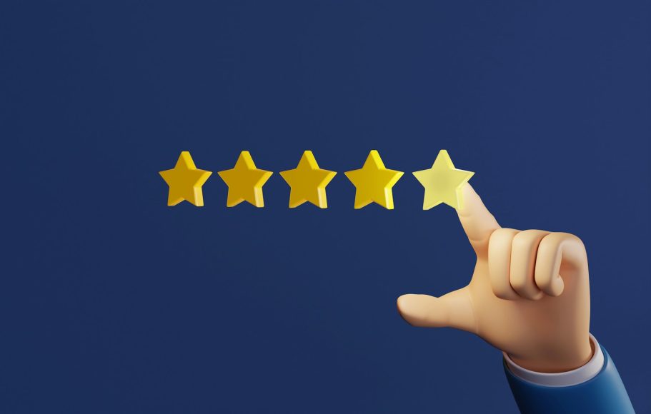 Main d'un homme pointant une étoile dorée pour évaluer un service, sur fond bleu.
